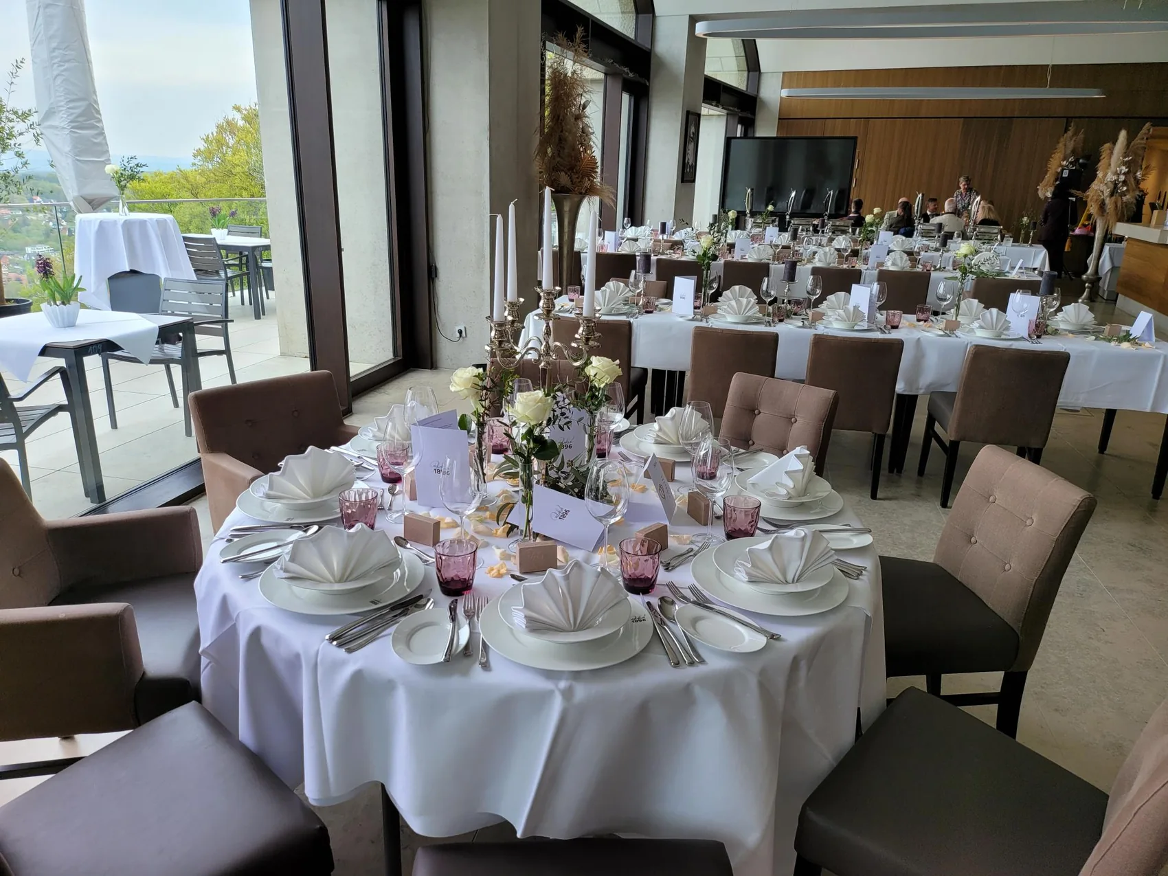 Festlich gedeckte Hochzeitstische mit Blumenschmuck und Gläsern