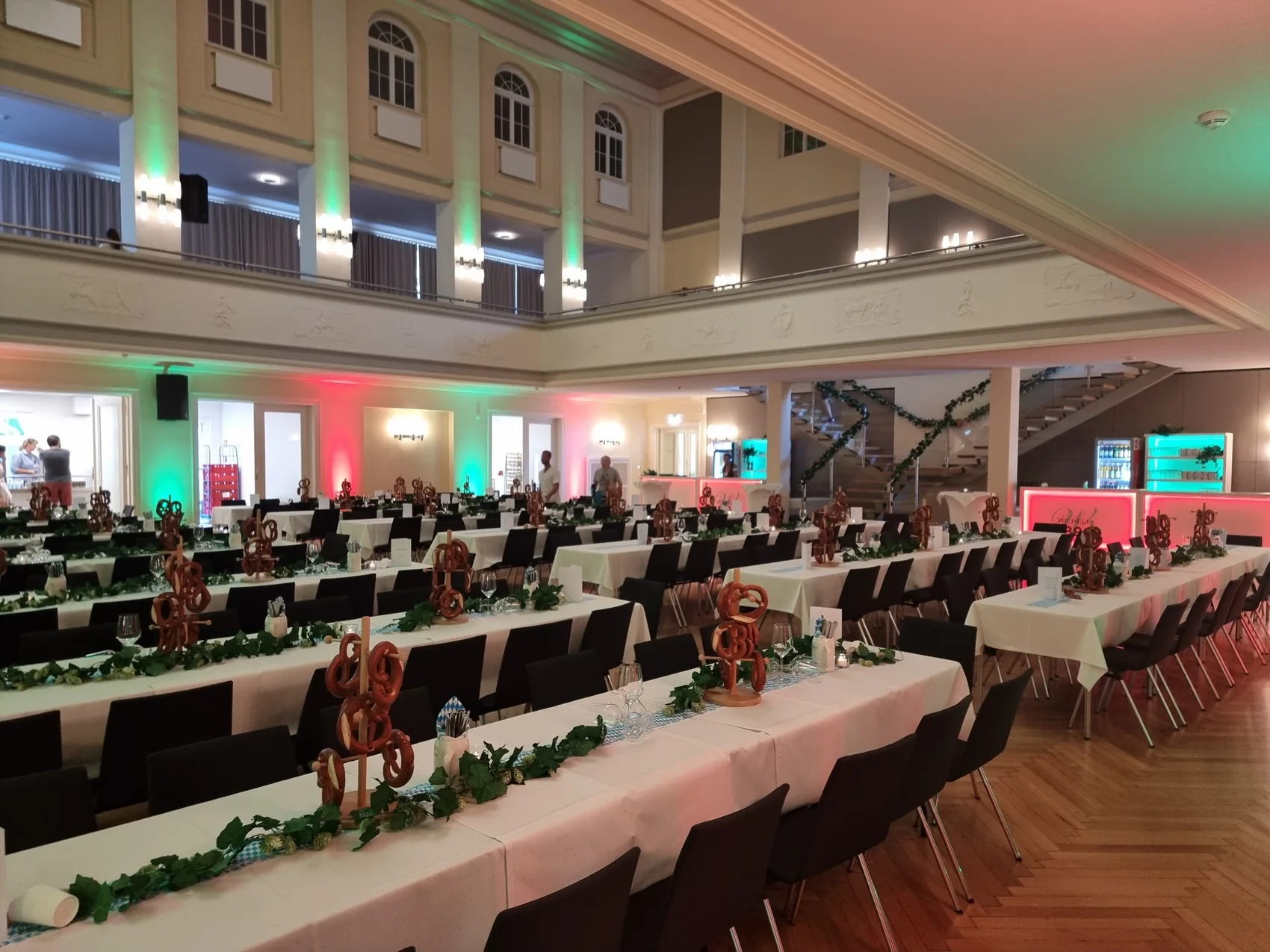 Festlich vorbereiteter Saal für ein Firmenevent mit langen Tafeln